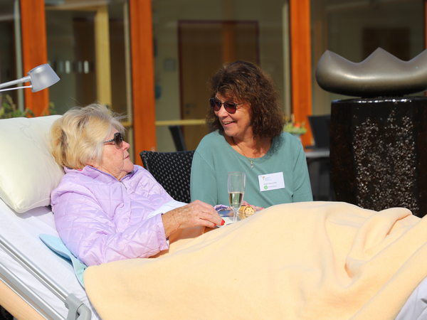 Hospizgästin in Patientenbett mit Betreuerin beim Frühstück auf der Terrasse des Albertinen Hospiz Norderstedt Hospizgästin in Patientenbett mit Betreuerin beim Frühstück auf der Terrasse des Albertinen Hospiz Norderstedt